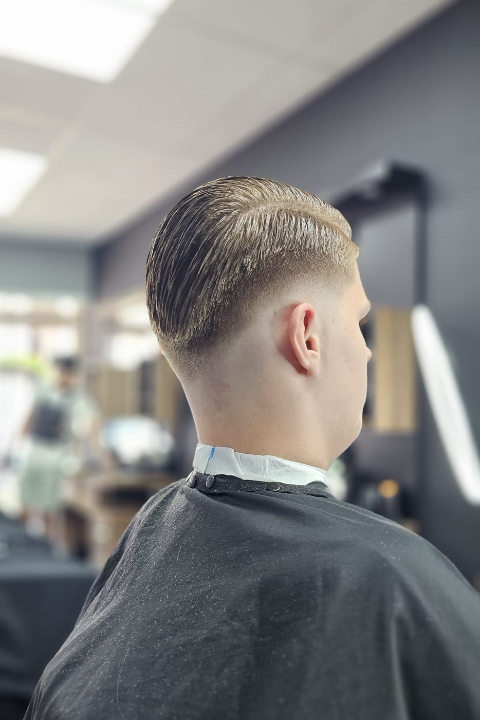 Achteraanzicht van een klant met een fade die naar de nek toe kort afloopt